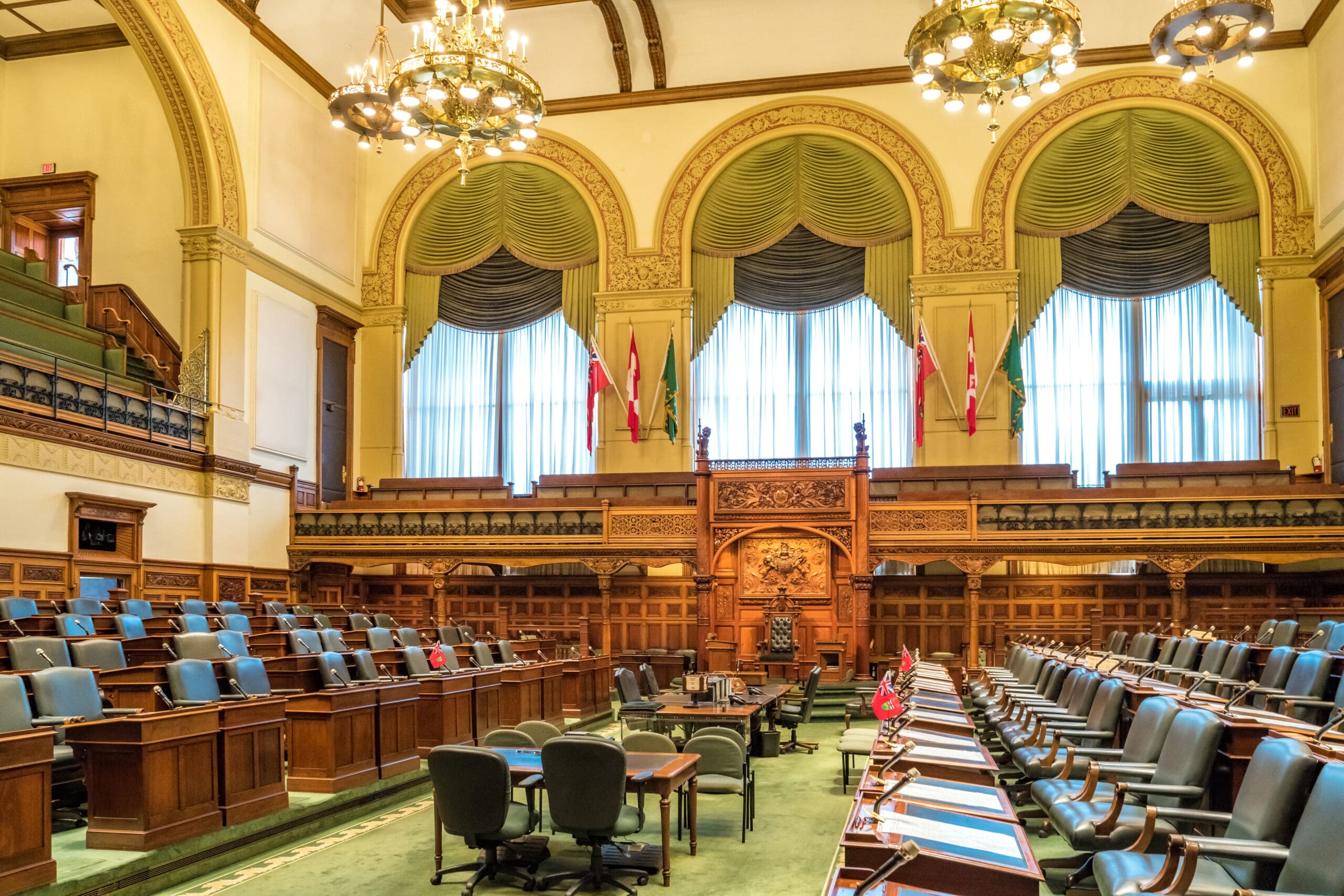 Ontario Legislative Building Interior with green and wood seats and three big windows with green drapery curtains