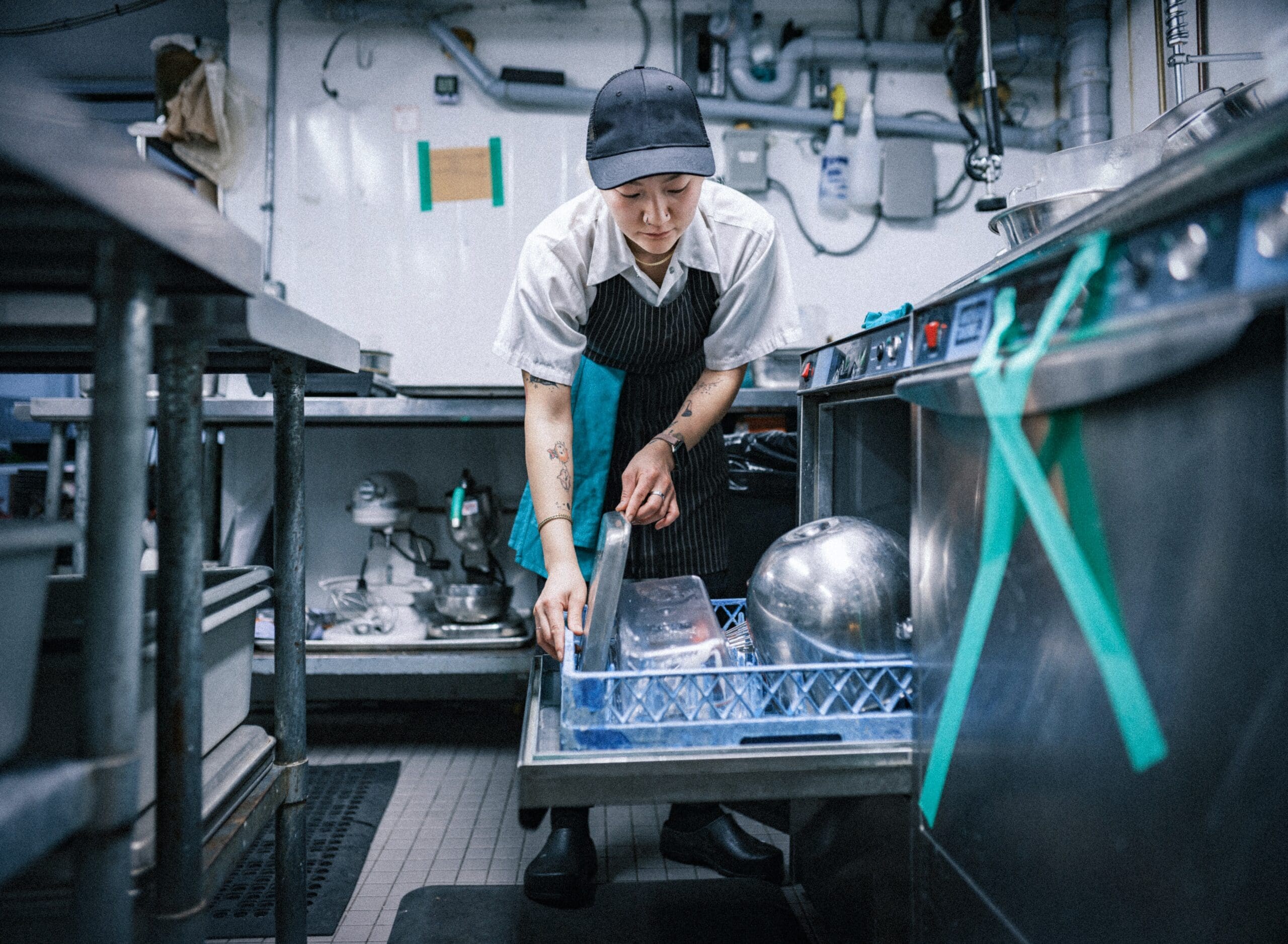 Person loading dishwasher in restaurant