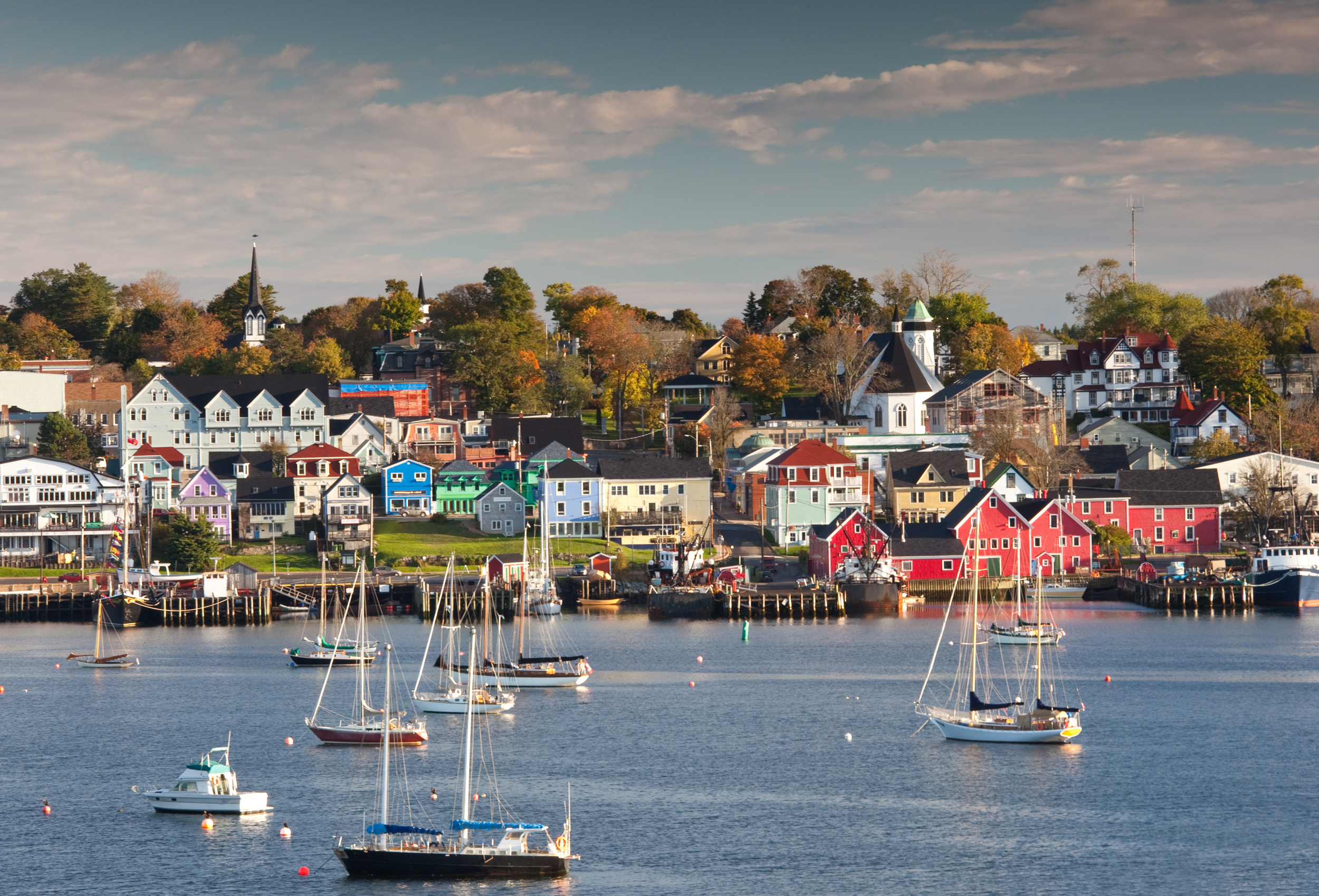 The beautiful and historic town of Lunenburg, Nova Scotia in the fall. Boats drift in the harbour and the amazing colours of the buildings in this picturesque seaside town add to the scene. This image was taken across the harbour from town on a gorgeous fall morning. Lunenburg is located approximately an hour from Halifax.