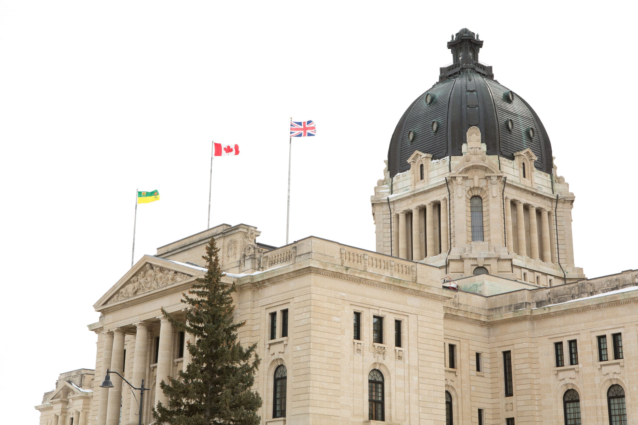 Saskatchewan Legislative Building in Regina, Saskatchewan, Canada. From left to right, the Saskatchewan, Canadian, and United Kingdom flags fly on the building.