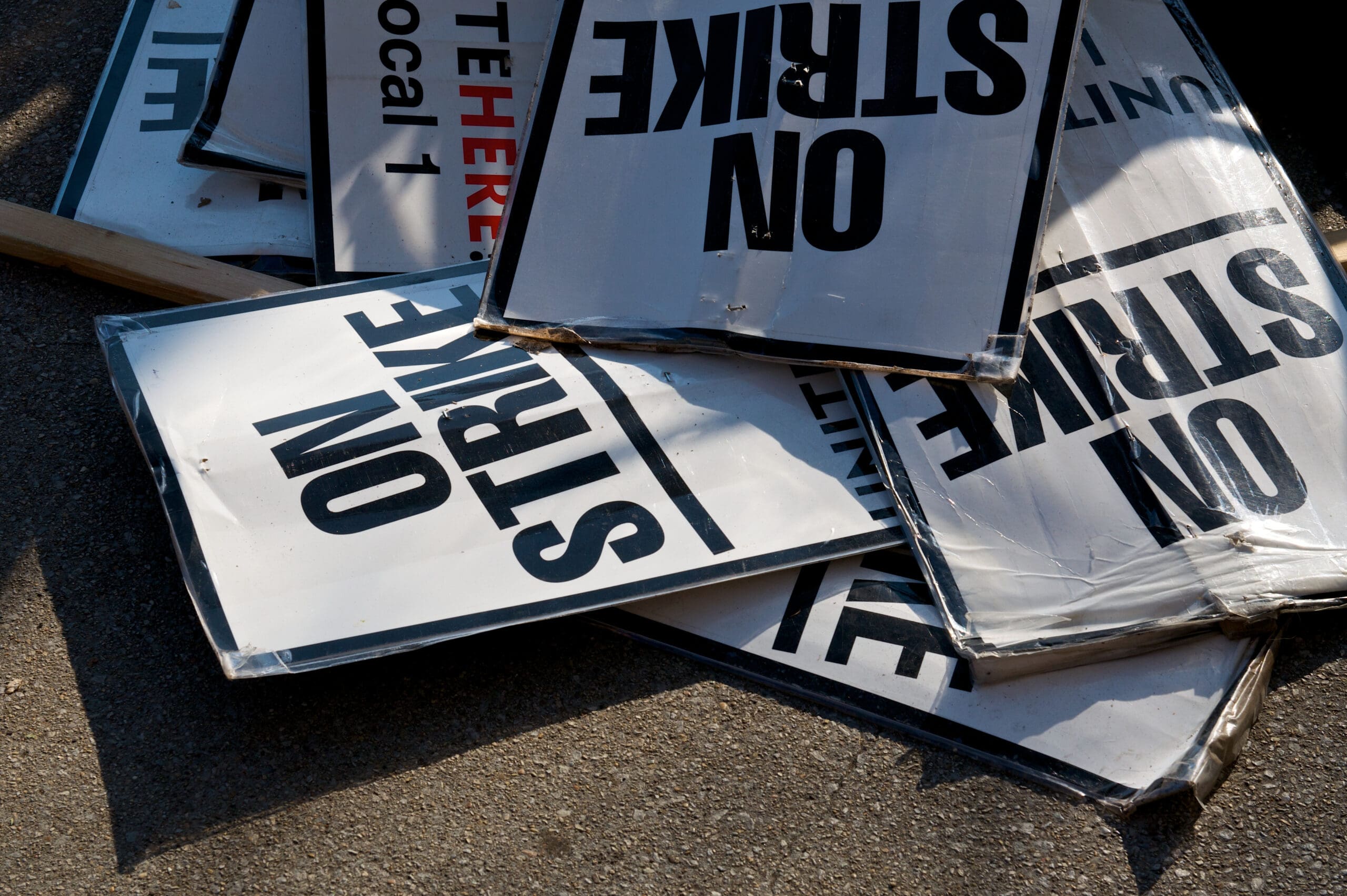 Discarded "on strike" signs in a pile.